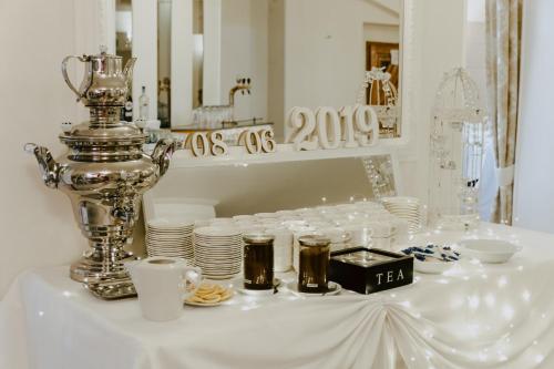 a table with plates and cups and a trophy on it at Hotel Kruk in Smardzewice