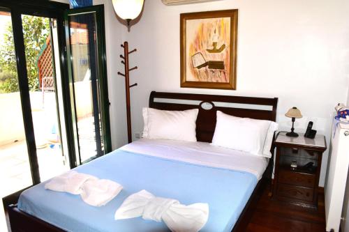 a bedroom with a blue bed with towels on it at Villa Artemis in Aegina Town