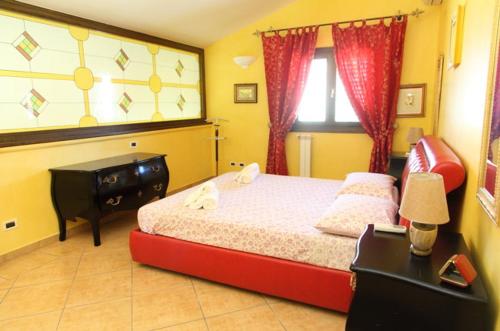 a bedroom with a bed and a desk and a window at Villa lipari in Cefalù