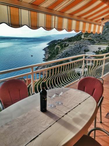 a table with wine glasses on top of a balcony at Apartment Bellavita Senj in Senj