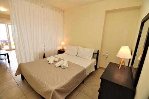 a hotel room with a bed with towels on it at Dolphins Apartments in Loutra Edipsou