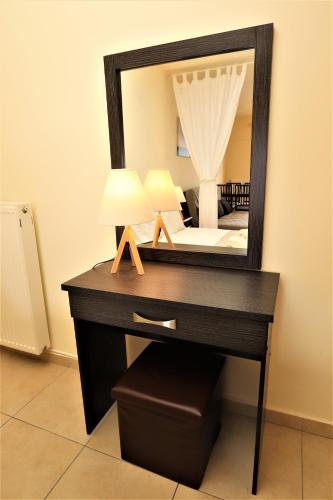 a desk with a mirror and a bed in a room at Dolphins Apartments in Loutra Edipsou