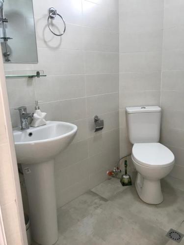 a bathroom with a toilet and a sink at Hotel CHARLI in Gonio