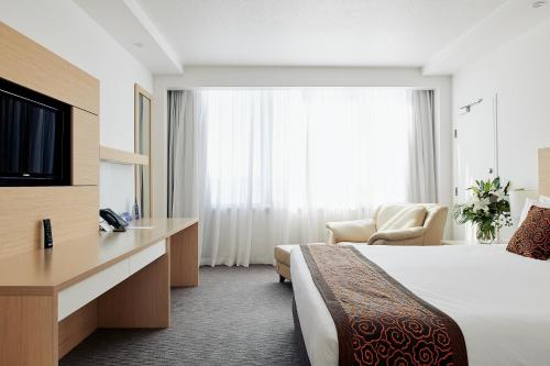 a hotel room with a bed and a television at The Ville Resort - Casino in Townsville