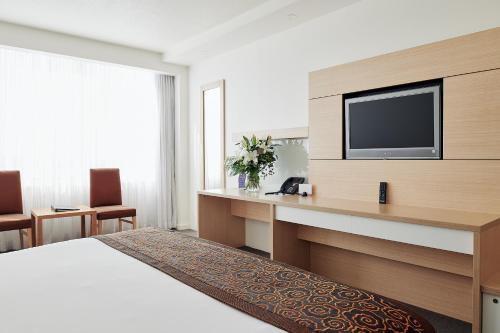 a hotel room with a bed and a flat screen tv at The Ville Resort - Casino in Townsville