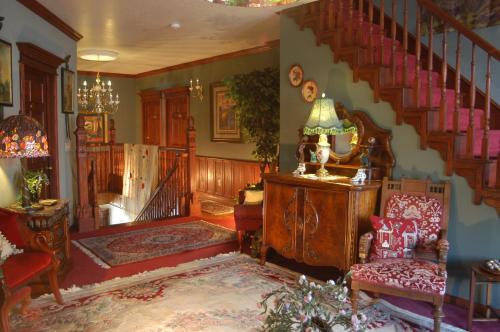 a living room with a staircase and a chair at Big Yellow Inn in Cedar City