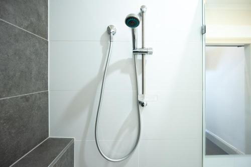 a shower with a shower head in a bathroom at The Mile End Hotel in Adelaide