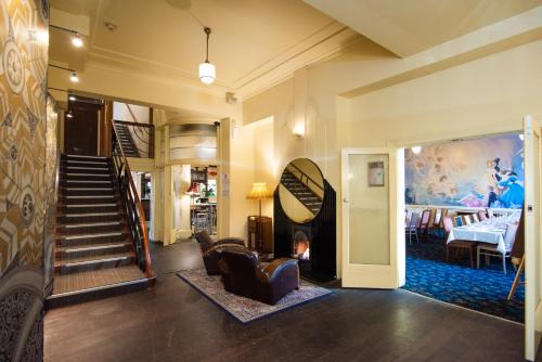 a living room with a staircase and a dining room at The Mile End Hotel in Adelaide