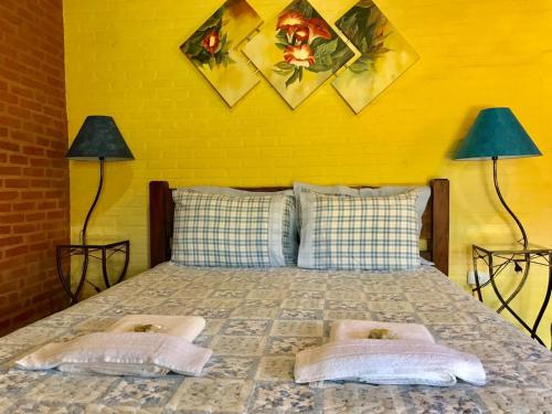 a bed with two lamps and two pillows on it at Pousada Recanto da Siriema in Monte Alegre do Sul