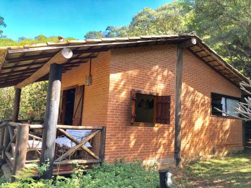 a small brick house with a window and a fence at Pousada Recanto da Siriema in Monte Alegre do Sul