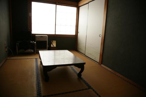 a table in an empty room with a window at Magome Chaya in Nakatsugawa