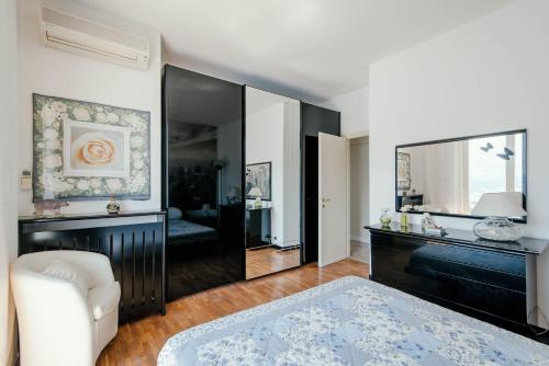 a bedroom with a large mirror and a white chair at Villa Fantastica in Carate Urio