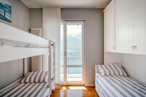 two bunk beds in a room with a large window at Villa Fantastica in Carate Urio