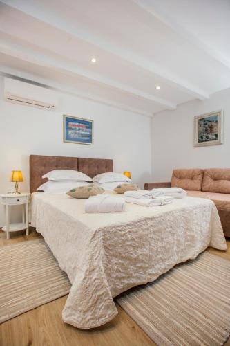 a bedroom with a large bed and a couch at Boutique Room Kaliopi in Hvar