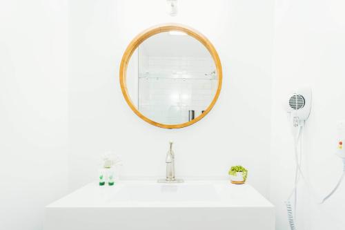 a bathroom with a mirror on a sink at The Belmont Shore Inn in Long Beach