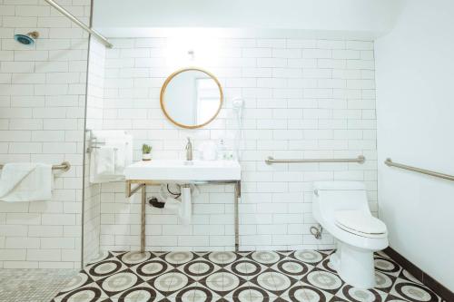 a white bathroom with a sink and a toilet at The Belmont Shore Inn in Long Beach