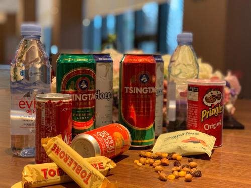 a table topped with soda cans and other food items at Ramada Encore by Wyndham Gimpo Han River Hotel in Gimpo