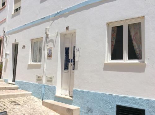 a white and blue building with a window at Casa Alzira By ALzira in Albufeira