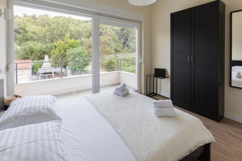 sypialnia z łóżkiem i dużym oknem w obiekcie Villa Lele - peace, mountain & sea view, heated pool w mieście Novigrad