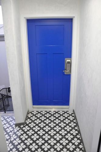 a blue door in a hallway with a tile floor at The Belmont Shore Inn in Long Beach