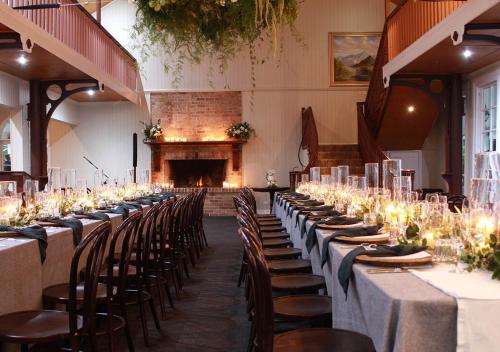 a row of tables and chairs in a room with a fireplace at Hampton Estate Wines in Mount Tamborine