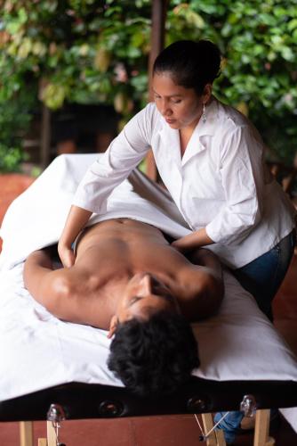 a woman is getting a mans back on a bed at La Bambouseraie in Balgue
