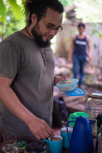 a man holding a bowl of food on a table at La Bambouseraie in Balgue