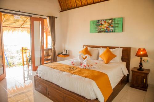 a bedroom with a large bed and a sliding glass door at Dayuh House in Nusa Penida