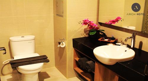 y baño con aseo blanco y lavamanos. en Arch Hotel Bogor, en Bogor