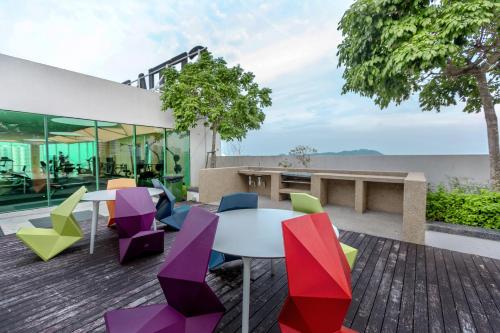 a patio with colorful chairs and a table at Cozy Home with Spectacular View in Bayan Lepas