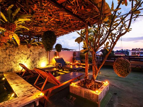 a patio with a table and chairs and a tree at Ban Kong Rao Guesthouse in Chiang Mai