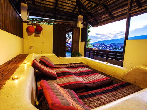 a room with a couch and pillows on a balcony at Ban Kong Rao Guesthouse in Chiang Mai