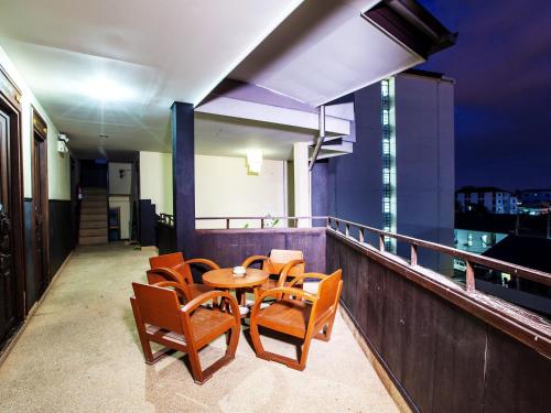 a balcony with a table and chairs on a building at Ban Kong Rao Guesthouse in Chiang Mai