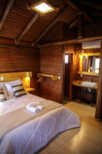 a bedroom with a large bed with towels on it at Pousada Morada da Serra in Cambará