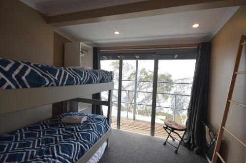 a bedroom with two bunk beds and a large window at Fountains 18 in Mount Hotham