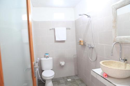 a bathroom with a toilet and a sink and a shower at Dayuh House in Nusa Penida