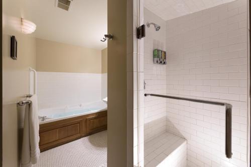 a bathroom with a shower and a bath tub at Lake Pointe Inn in McHenry