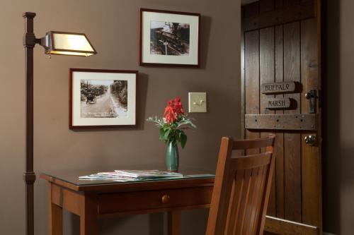 a desk with a vase of flowers on top of it at Lake Pointe Inn in McHenry