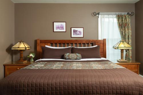 a bedroom with a large bed with two lamps at Lake Pointe Inn in McHenry