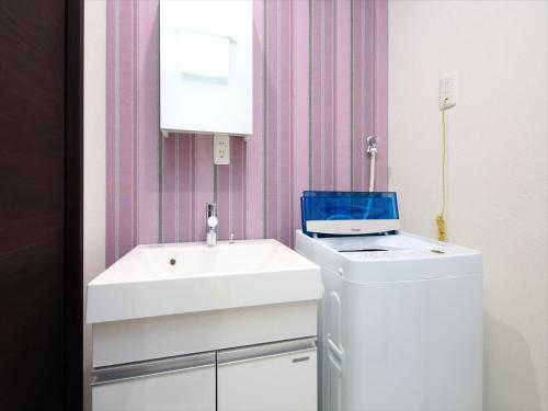 a bathroom with a white sink and a counter at COTO Tokyo Nakano in Tokyo