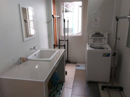 a bathroom with a sink and a washing machine at Baan Malee in Phuket Town