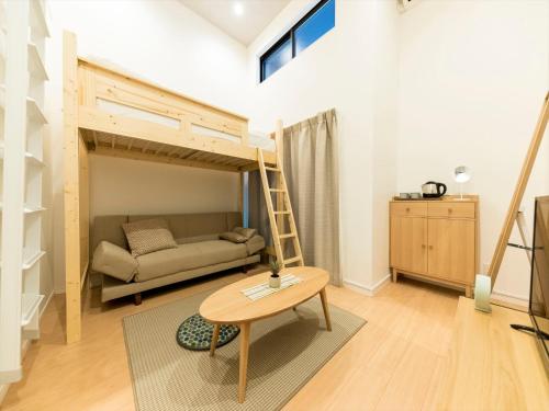 Sala de estar con cama, sofá y mesa en TRIP POD TAKASAGO B, en Fukuoka