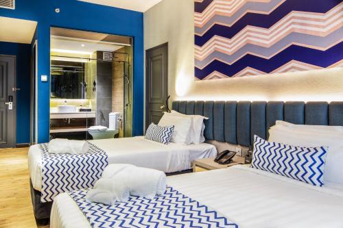 a hotel room with two beds and a bathroom at TROVE Johor Bahru in Johor Bahru
