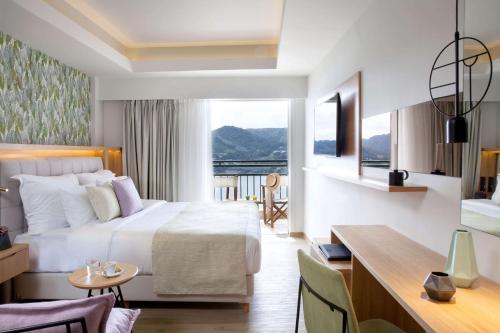 a hotel room with a bed and a desk at Dolce by Wyndham Athens Attica Riviera in Vravrona