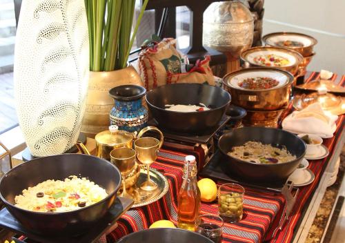 a table topped with bowls of food and other dishes at The Trans Luxury Hotel Bandung in Bandung