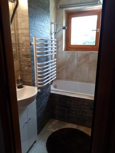 a bathroom with a sink and a tub and a window at U Hanki in Biały Dunajec