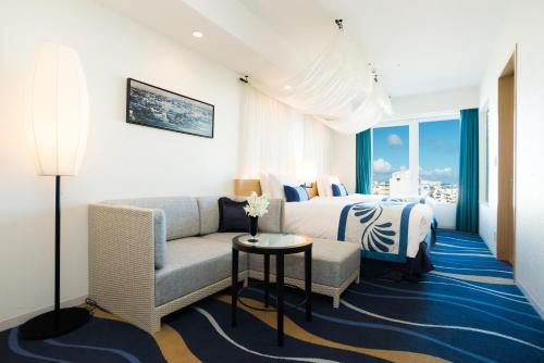 a hotel room with a bed and a couch at Rihga Royal Gran Okinawa in Naha