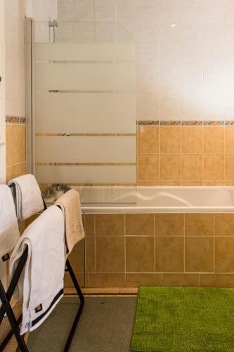 La salle de bains est pourvue d'une baignoire et d'un tapis vert. dans l'établissement la Casa D'estève, à Bourges