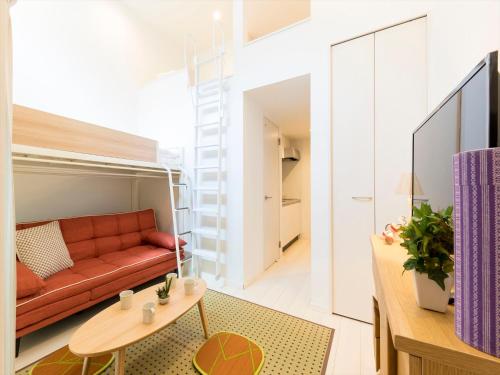 una sala de estar con un sofá y una mesa en TRIP POD TAKASAGO A, en Fukuoka