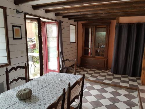 ein Esszimmer mit einem Tisch und einem karierten Boden in der Unterkunft Le Logis De Judicael in Paimpont